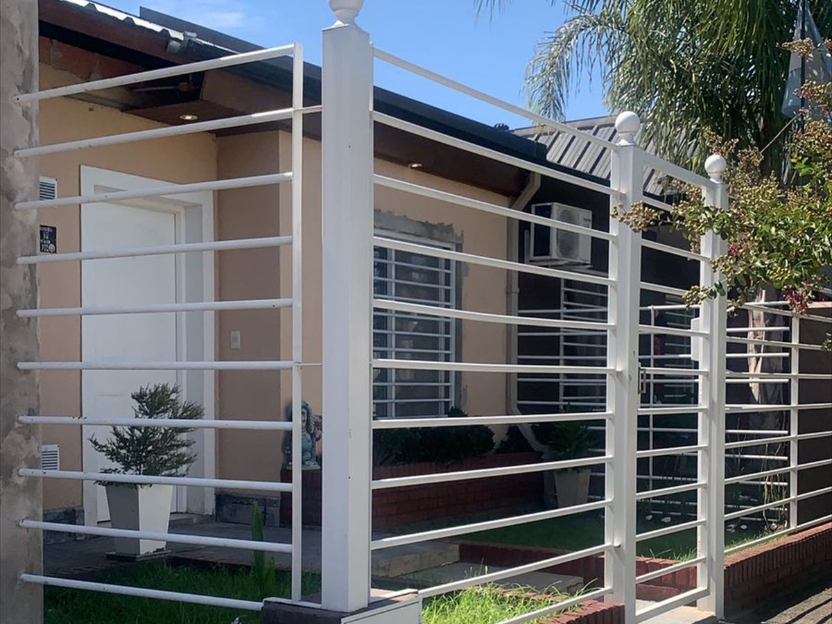 Reja blanca a medida instalada en el frente de una vivienda